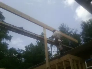 Carpenter setting a ridge beam over a new addition frame — Ice Dam Removal by Roofing Brothers in Liverpool