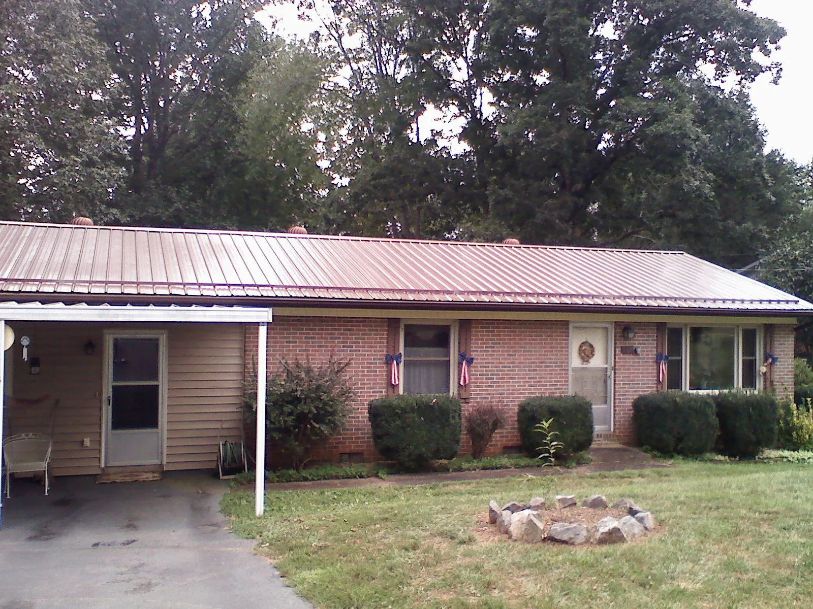 Bronze metal roof and carport on a brick ranch home — Roof Repair work by our crew in Liverpool